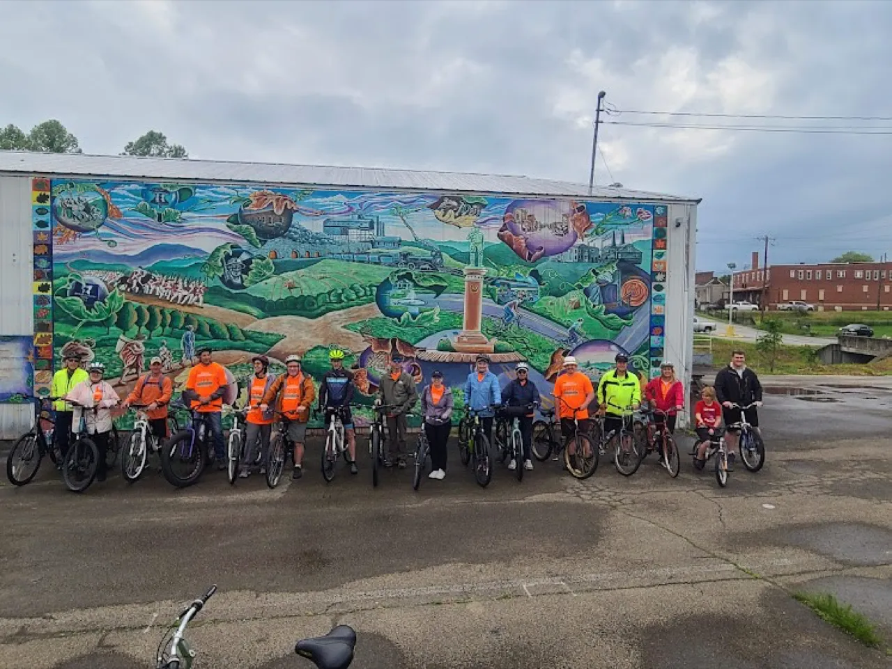 Cyclists beside a mural on the Coal & Coke Trail