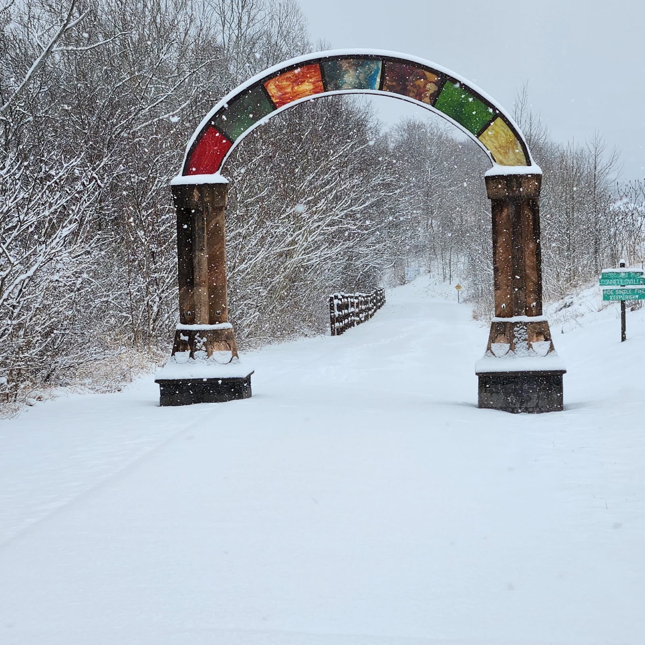 A stone railroad arch surviving along a former rail corridor, now a trail